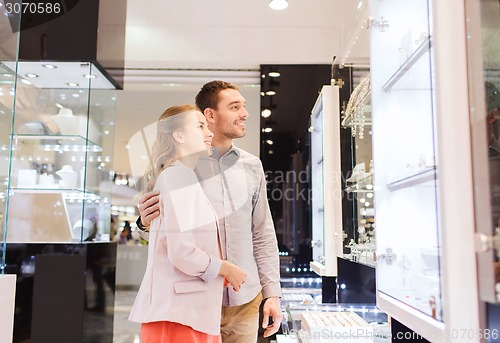 Image of couple looking to shopping window at jewelry store