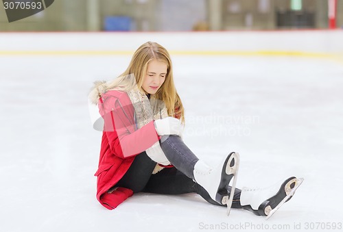 Image of young woman fell down on skating rink