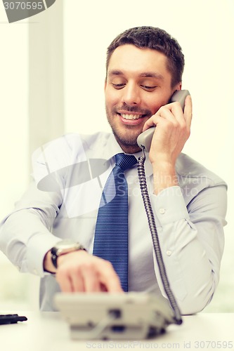 Image of smiling businessman with telephone dialing number