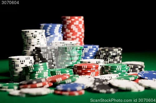 Image of close up of casino chips on green table surface