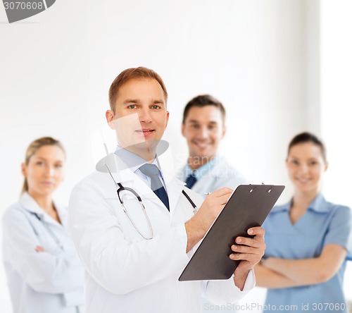 Image of smiling male doctor with clipboard and stethoscope