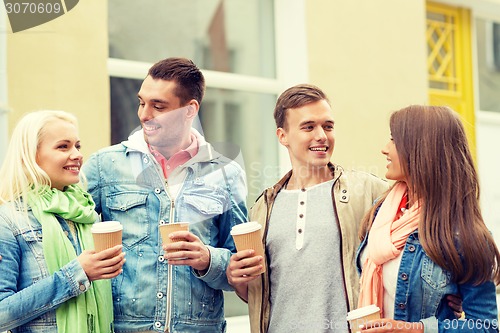 Image of group of smiling friends with take away coffee