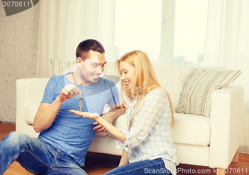 Image of man giving keys to girlfriend or wife at home