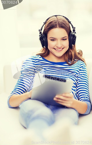 Image of girl with tablet pc and headphones at home