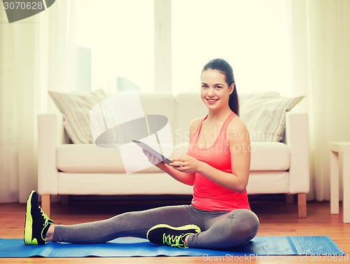 Image of smiling teenage girl streching on floor at home