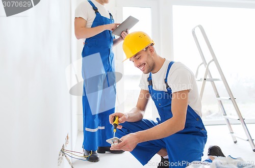 Image of builders with tablet pc and equipment indoors