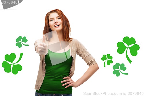 Image of smiling teen girl with shamrock showing thumbs up