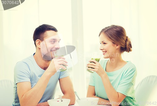 Image of smiling couple having breakfast at home