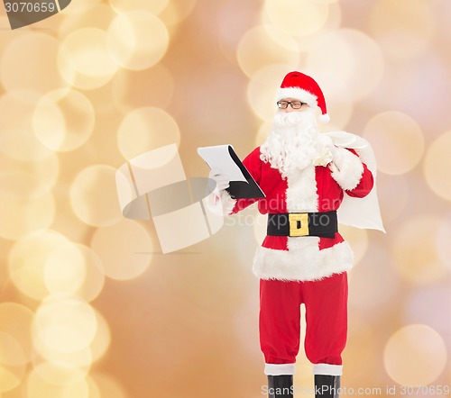 Image of man in costume of santa claus with notepad and bag