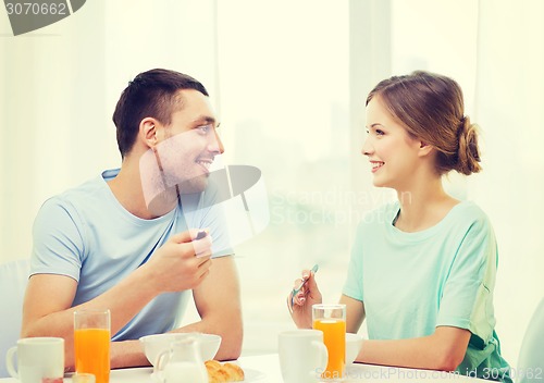 Image of smiling couple having breakfast at home