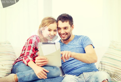 Image of smiling couple with tablet pc computer at home