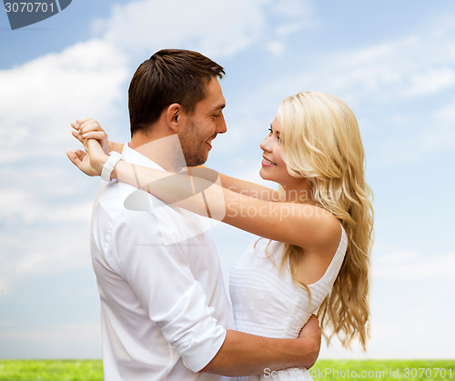 Image of happy couple hugging over natural background