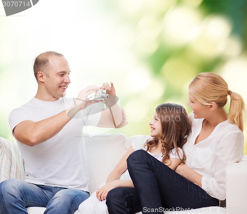 Image of happy family with camera at home