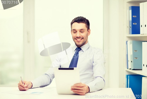 Image of smiling businessman with tablet pc and documents