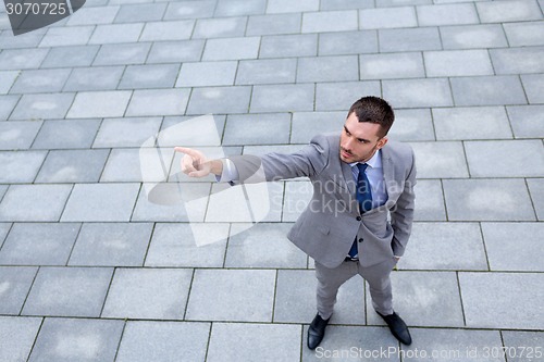 Image of young smiling businessman outdoors from top