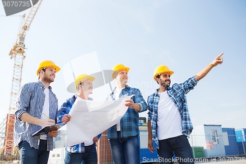 Image of group of builders with tablet pc and blueprint