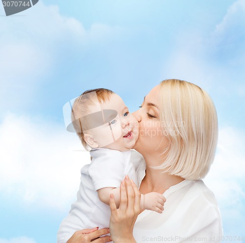 Image of happy mother kissing smiling baby