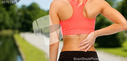 Image of close up of sporty woman touching her back