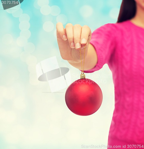 Image of close up of woman in sweater with christmas ball