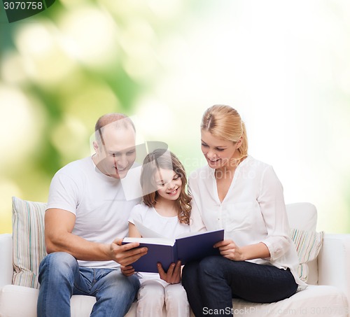 Image of happy family with book at home