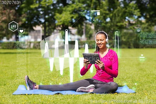 Image of smiling woman with tablet pc outdoors