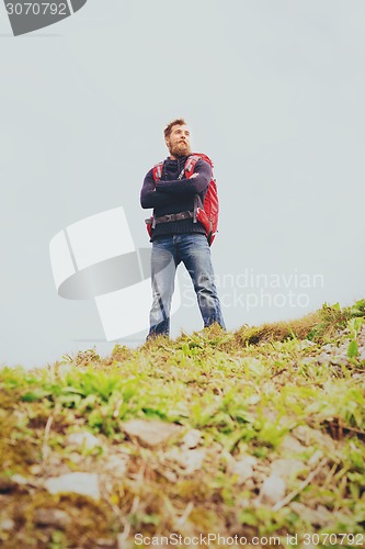 Image of smiling man with backpack hiking