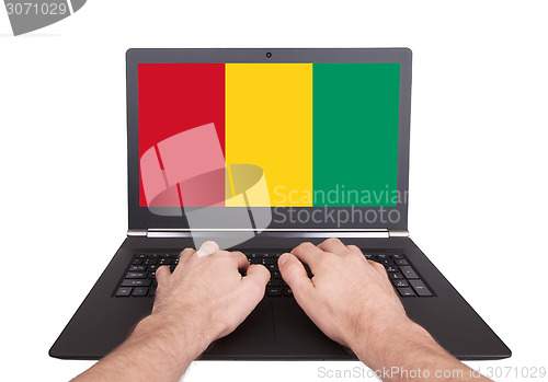 Image of Hands working on laptop, Guinea