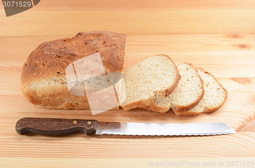 Image of Three slices cut from a loaf of bread with a knife