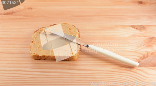 Image of Spreading peanut butter onto a slice of bread