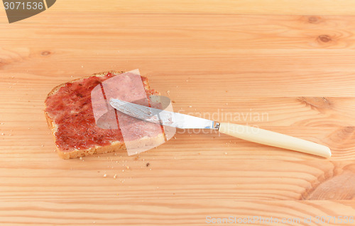 Image of Spreading jam on fresh bread with a knife