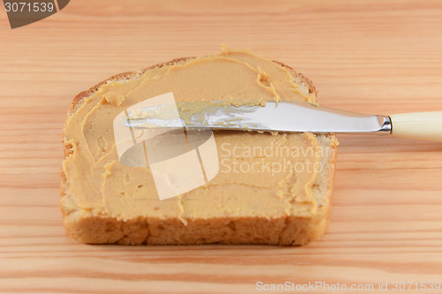Image of Smooth peanut butter being spread onto bread