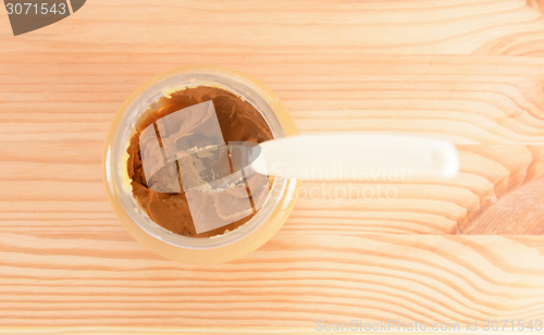 Image of Knife rests in a jar of smooth peanut butter