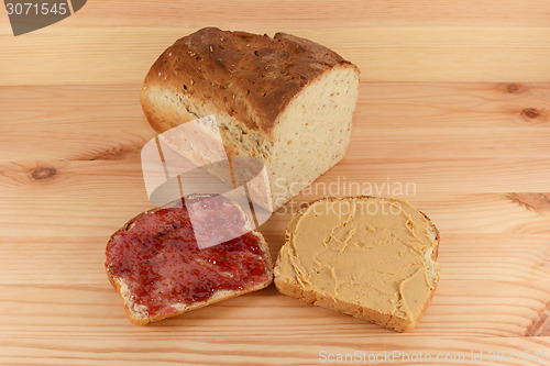 Image of Cut loaf of fresh bread with jelly and peanut butter slices