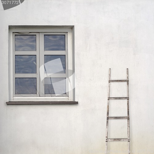 Image of stucco wall with window and wooden ladder