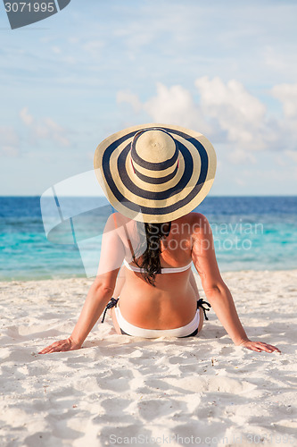 Image of Girl walking along a tropical beach in the Maldives.