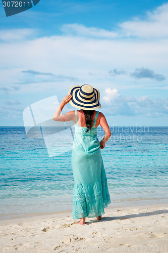 Image of Girl walking along a tropical beach in the Maldives.