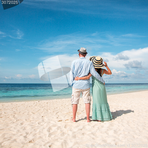 Image of Vacation Couple walking on tropical beach Maldives.