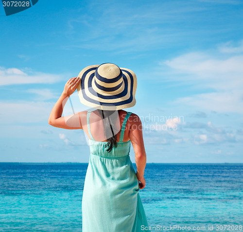 Image of Girl walking along a tropical beach in the Maldives.