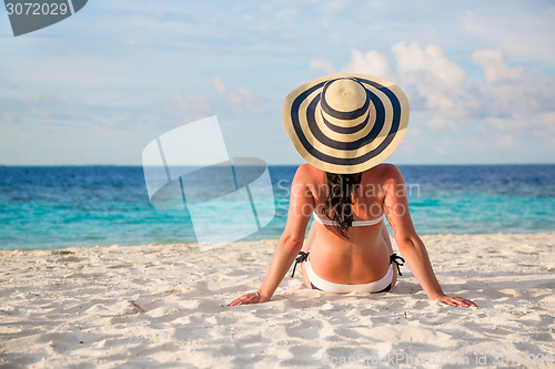 Image of Girl walking along a tropical beach in the Maldives.