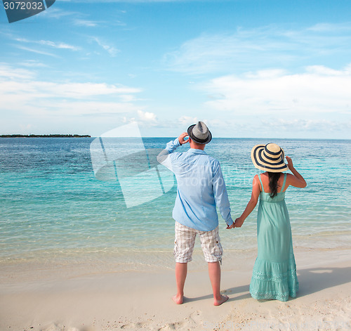 Image of Vacation Couple walking on tropical beach Maldives.