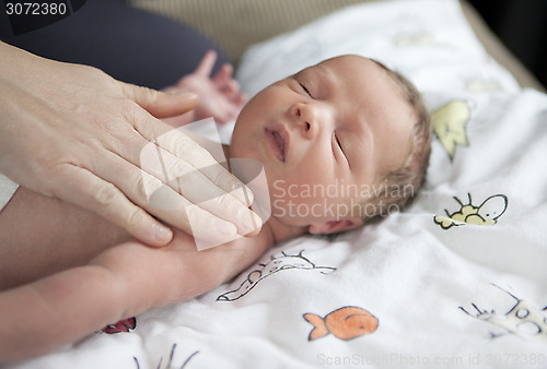 Image of infant being caressed