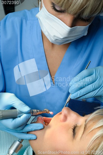 Image of dentist with patient, polishing and finishing