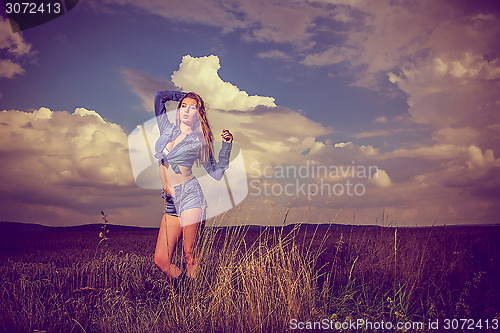 Image of attractive brunette girl in jeans, outdoor scene