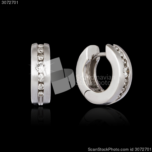 Image of White gold earrings isolated on the black background 