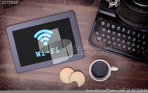 Image of Tablet with Wi-Fi connection on a wooden desk