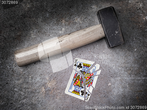 Image of Hammer with a broken card, king of clubs