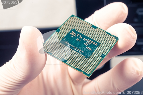 Image of Human hand holding modern processor