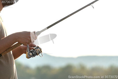 Image of Modern clean fishing rod in hands