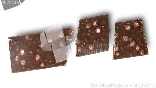 Image of Broken tiles of dark chocolate with whole hazelnuts