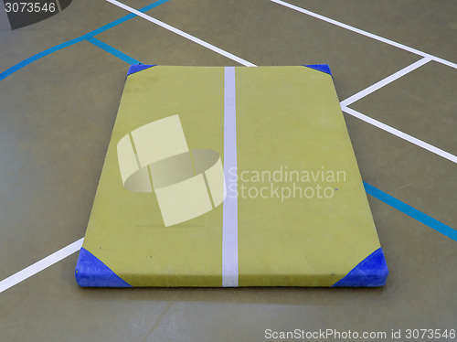 Image of Very old yellow mat on a blue court